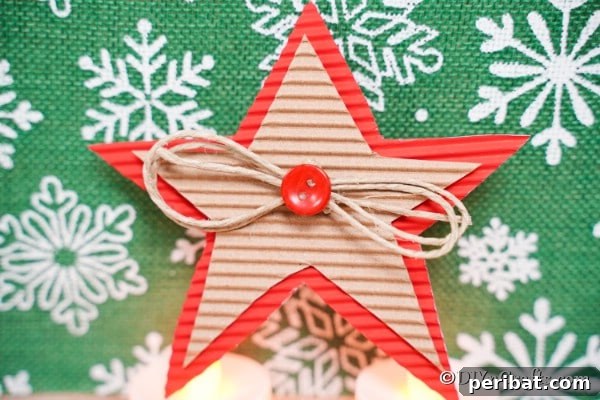 A cardboard star decoration on a green snowflake surface