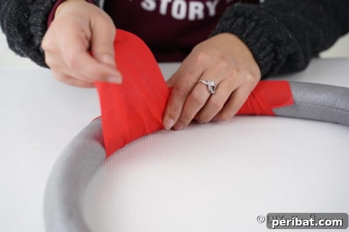 Deck Your Door: DIY Christmas Wreaths 7 Adding red fabric to a diy Christmas wreath