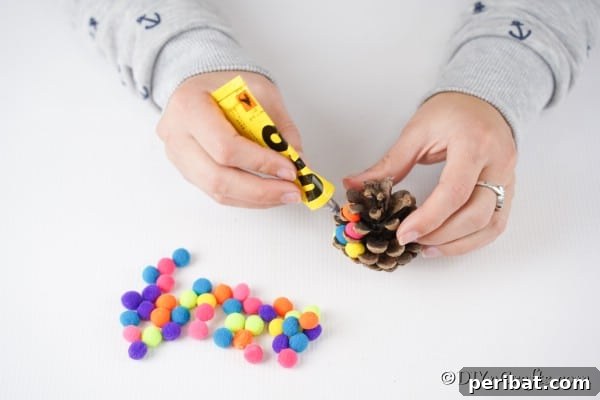 Vibrant Pinecone Christmas Decorations 12 Gluing pom poms onto a pinecone for an ornament
