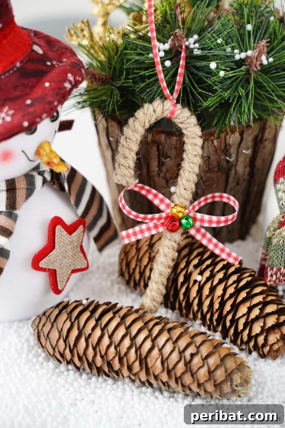 Farmhouse Jute Candy Cane Bauble 5 Candy can ornament in front of some pinecones