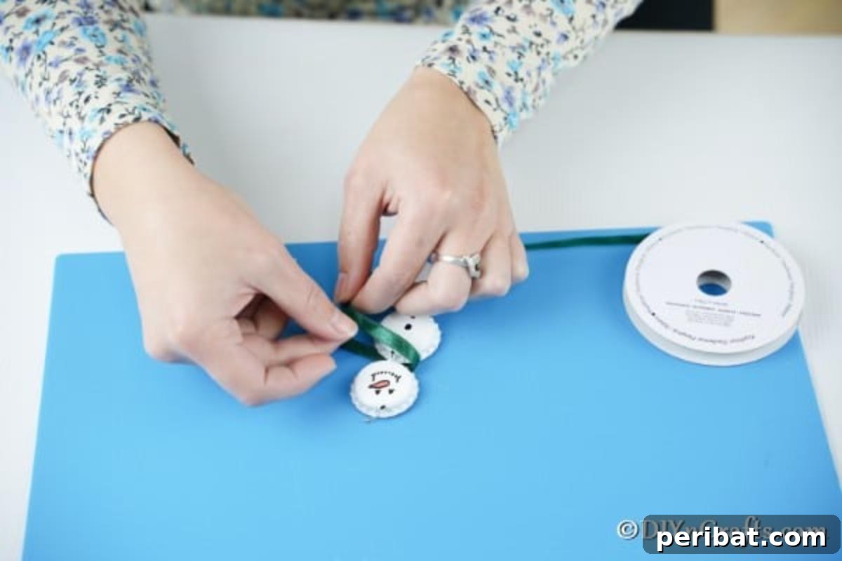 Upcycled Bottle Cap Snowman Charms 12 Tying a ribbon onto the bottle cap snowman ornaments