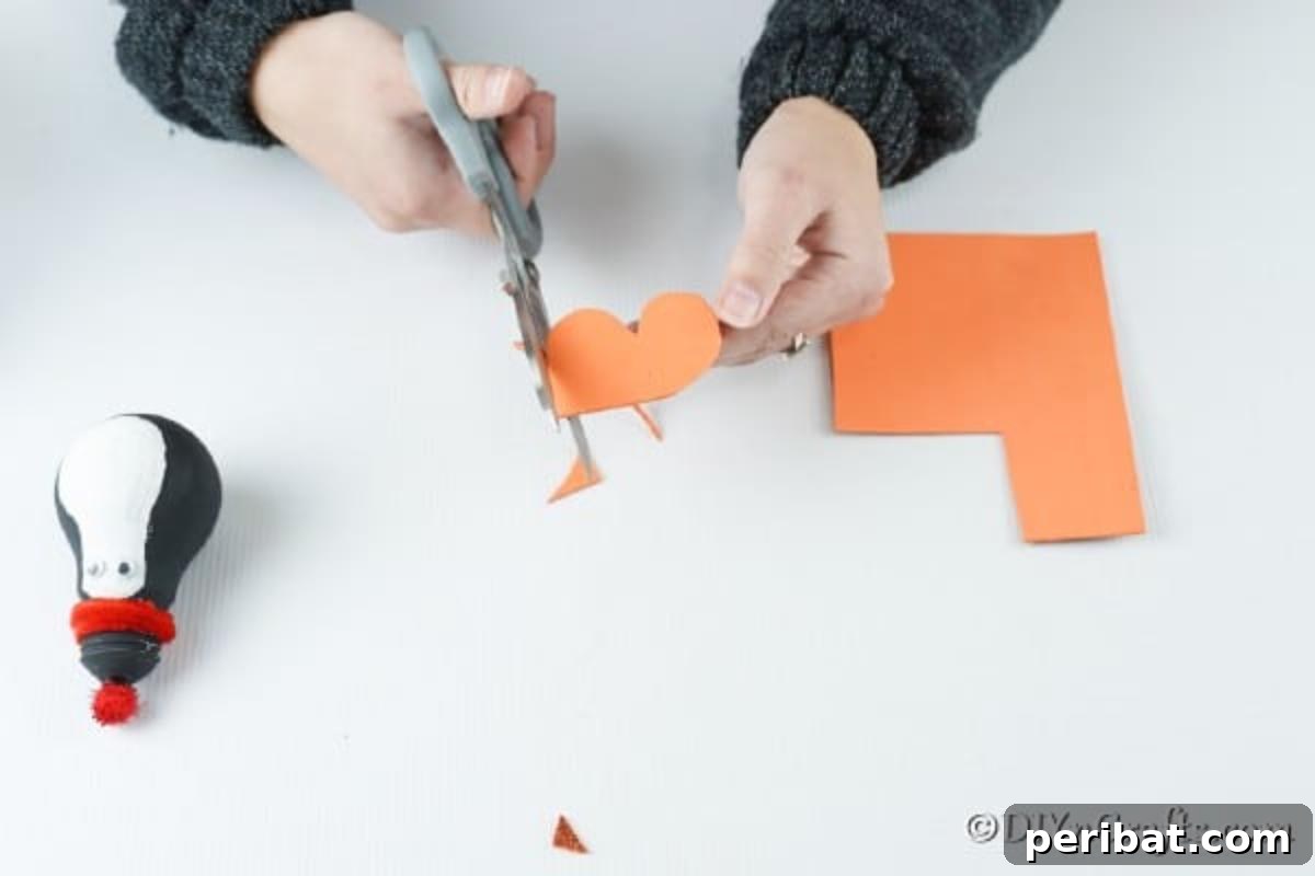 Cutting out orange feet from the penguin