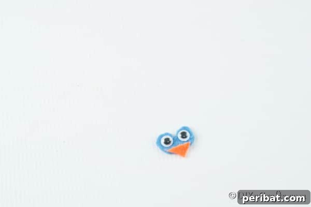Whimsical Winter Pinecone Owl Decorations 11 Adding googly eyes and an orange felt beak to the owl face