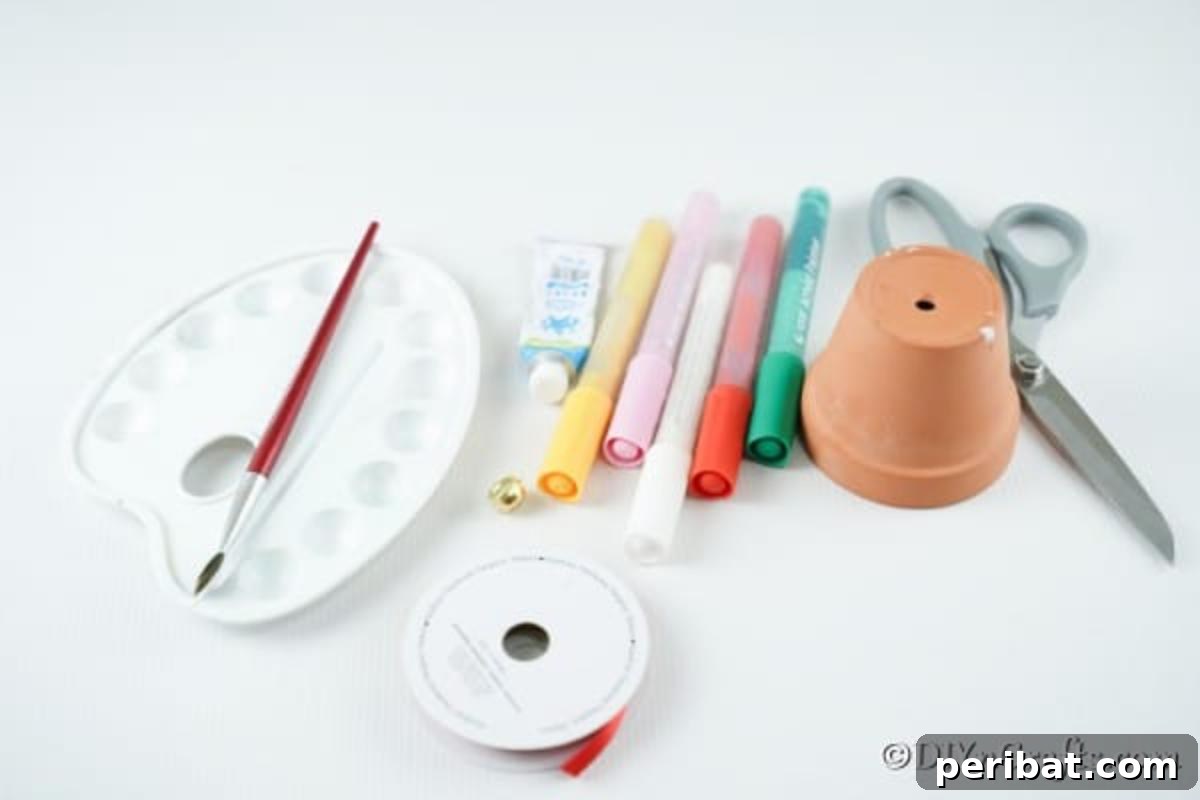 A flat lay of all the supplies needed to create a DIY clay pot gingerbread house, including a flower pot, paints, markers, ribbon, jingle bells, scissors, glue, and a paintbrush.