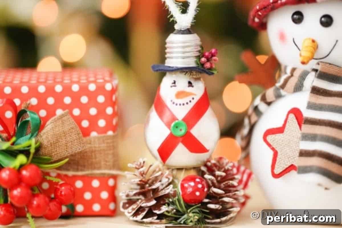 A light bulb snowman ornament elegantly hanging next to other holiday decorations on a Christmas tree