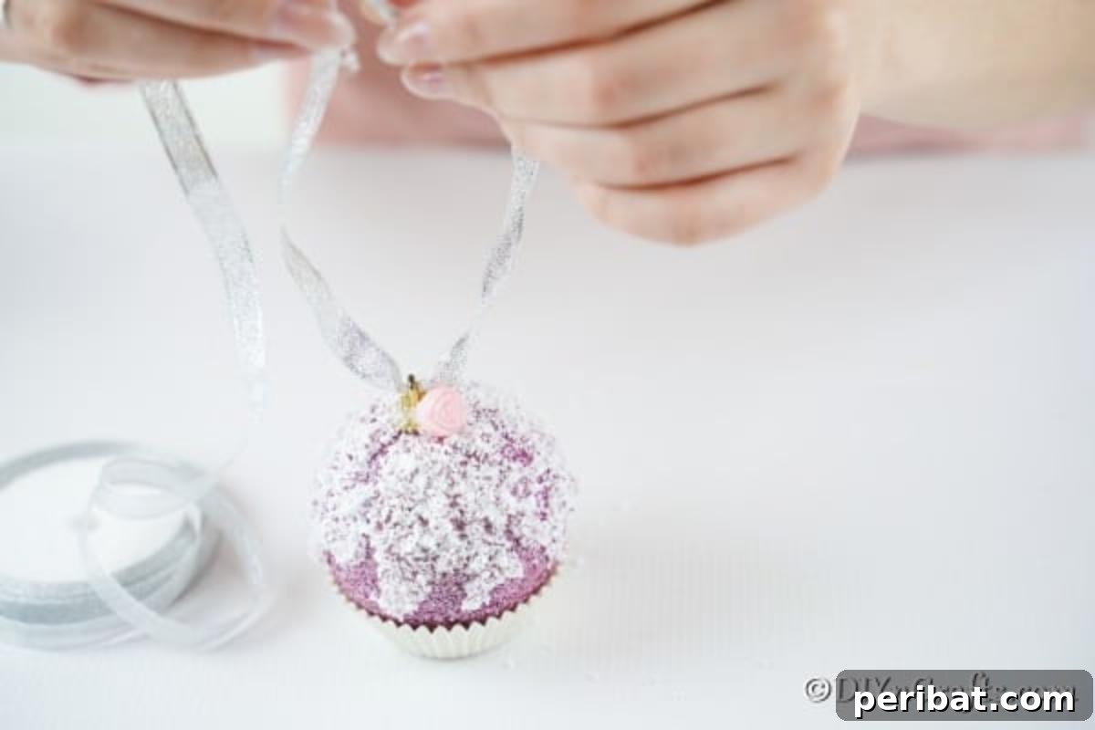 Sparkling DIY Cupcake Christmas Ornaments 11 Attaching a silver ribbon to the top of the ornament, creating a loop for hanging, completing the muffin or cupcake look