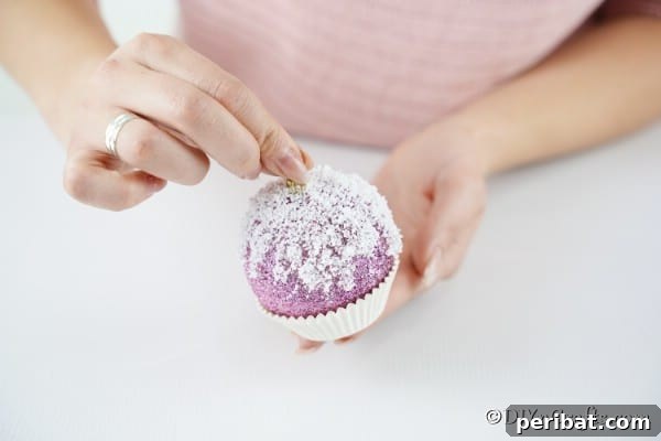 Gluing the Christmas ball into a paper muffin cup