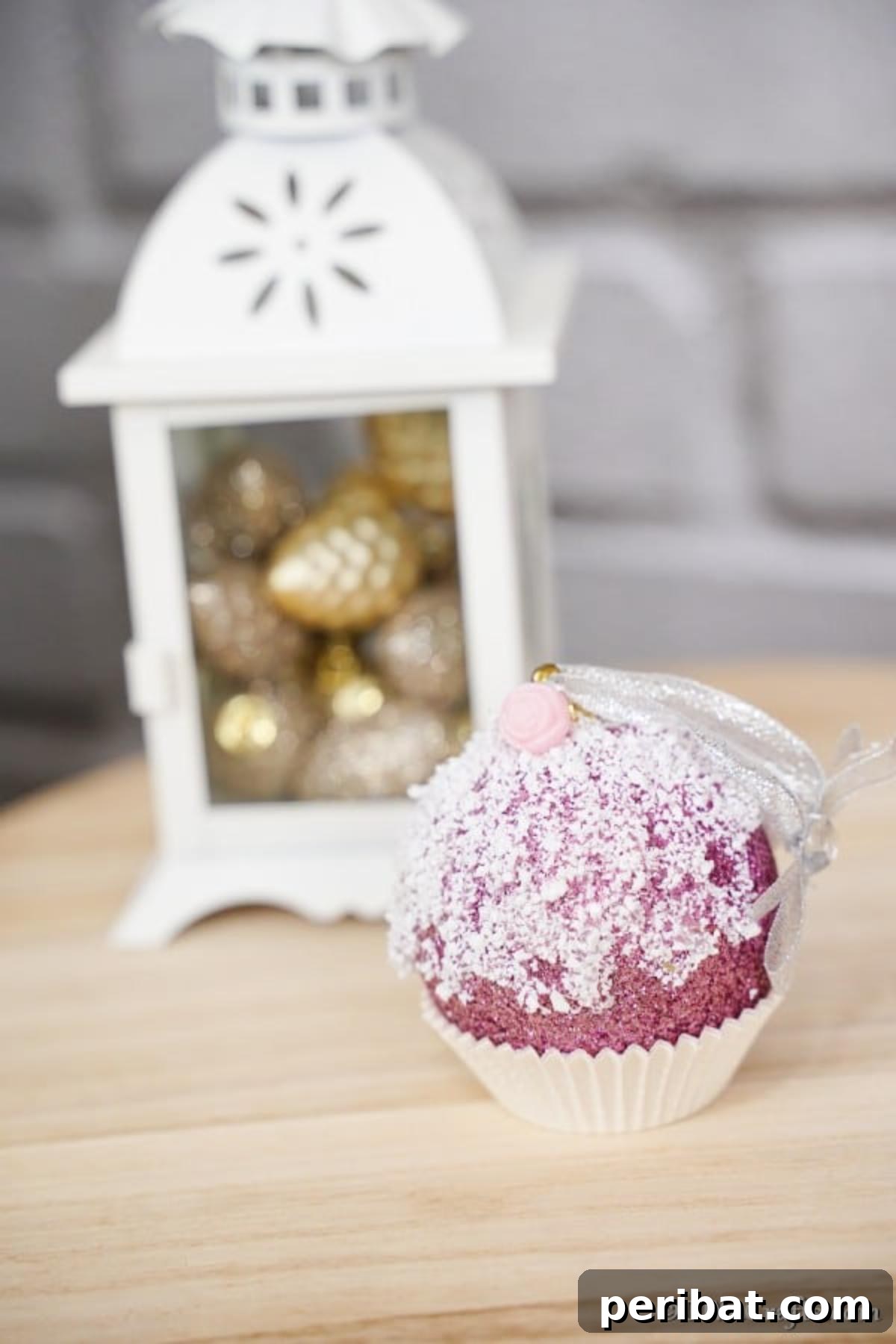 Sparkling DIY Cupcake Christmas Ornaments 3 Close-up of a festive cupcake ornament for a Christmas tree, placed in front of a white lantern