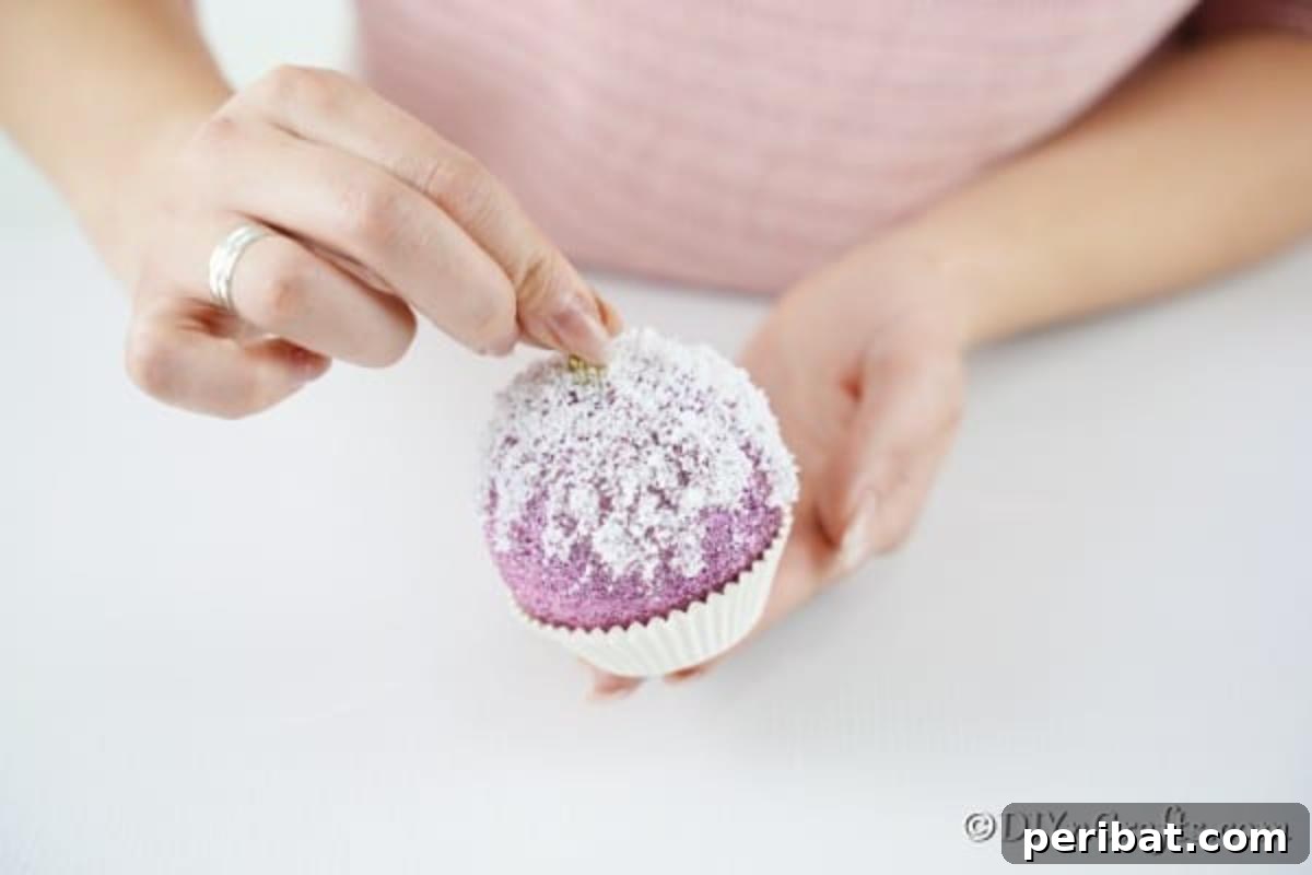Sparkling DIY Cupcake Christmas Ornaments 10 Securing the Christmas ball into a paper muffin cup with hot glue, positioning it as the base of the ornament