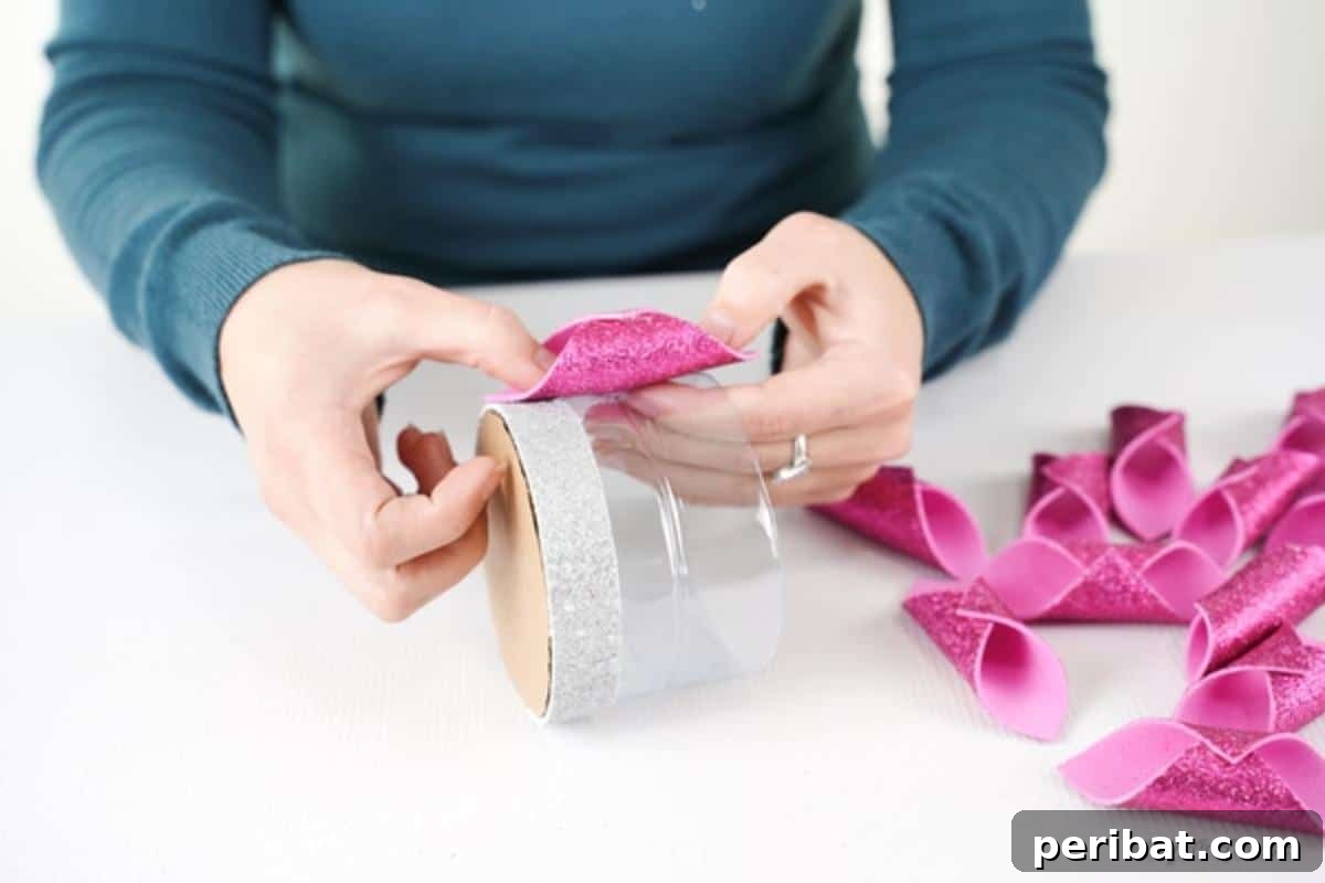 Shimmering Pink Paper Bloom Basket 17 Attaching pink cylinder to bottle base for basket, carefully placing each decorative piece