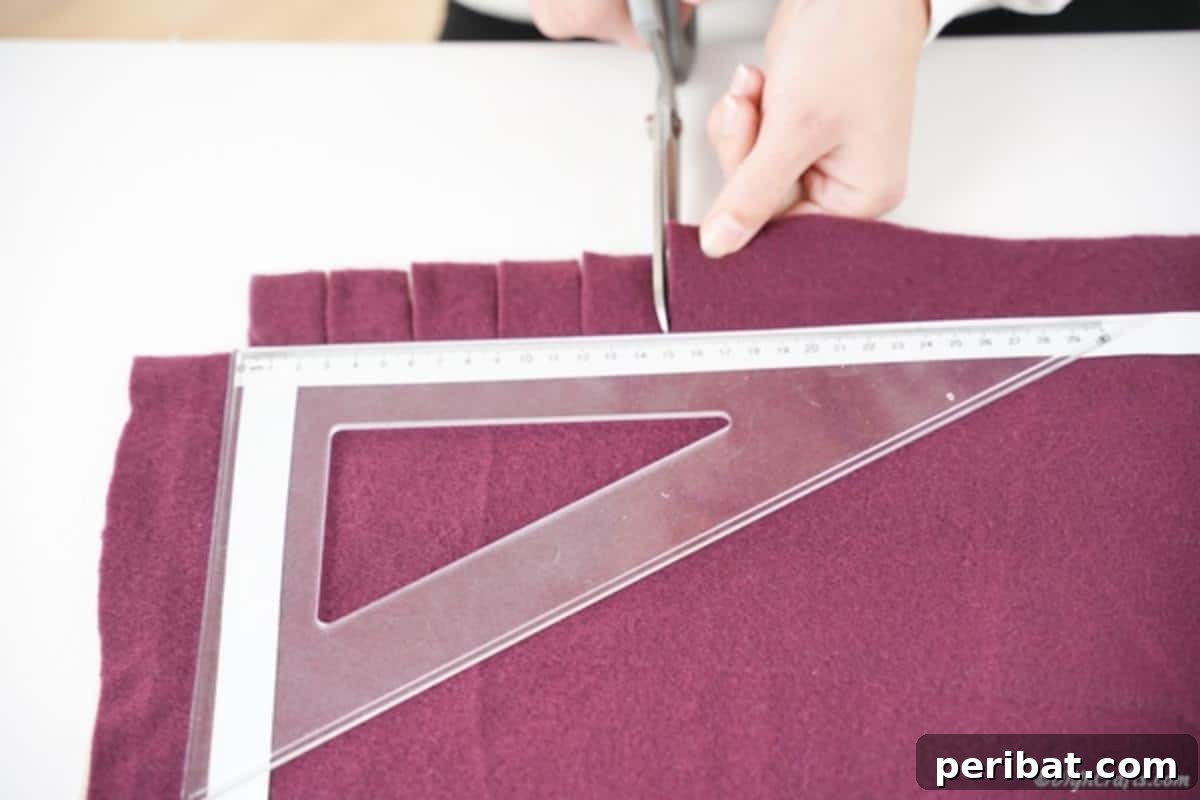 Easy 30-Minute No-Sew Reversible Fleece Pillow 9 Carefully cutting consistent slits into the stacked fabric, guided by the tape, to create the fringe.