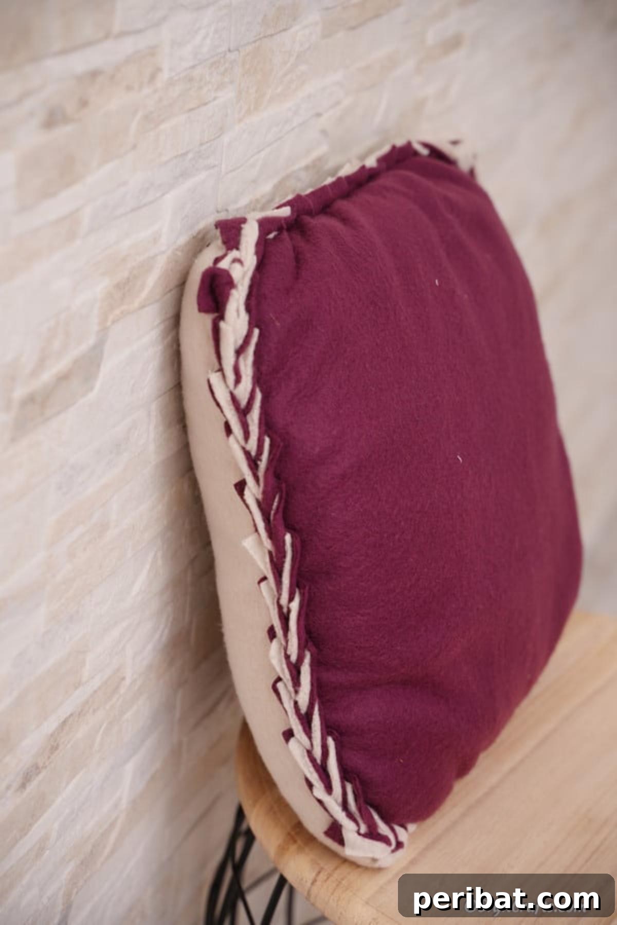 Easy 30-Minute No-Sew Reversible Fleece Pillow 18 A charming purple no-sew pillowcase leaning casually against a wall, showcasing its reversible design.