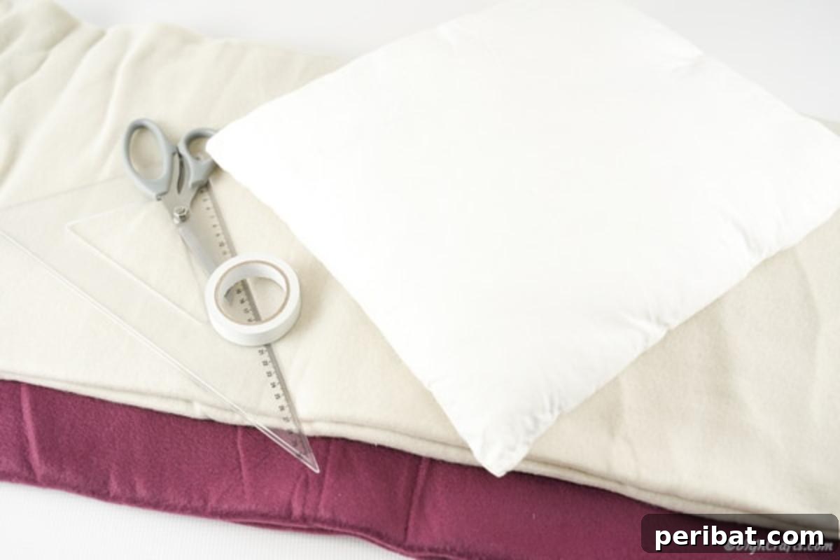 Easy 30-Minute No-Sew Reversible Fleece Pillow 5 A collection of supplies neatly arranged for a no-sew pillow project: fabric, scissors, ruler, and tape.