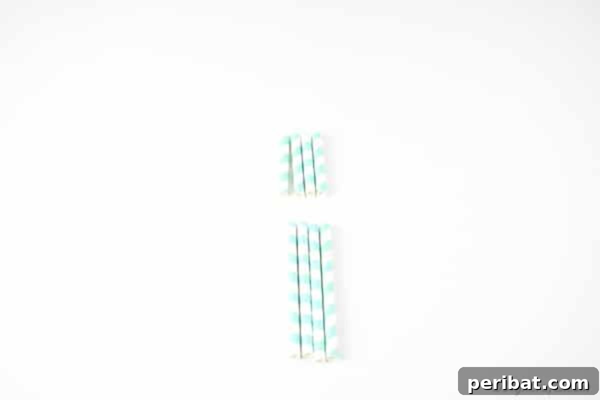 Four paper straws neatly cut into two different sizes, demonstrating the 1/3 and 2/3 length divisions required for the project.