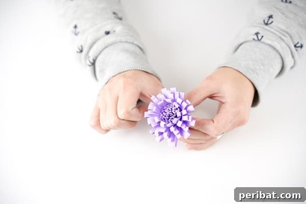 Finishing paper flower by gluing in place