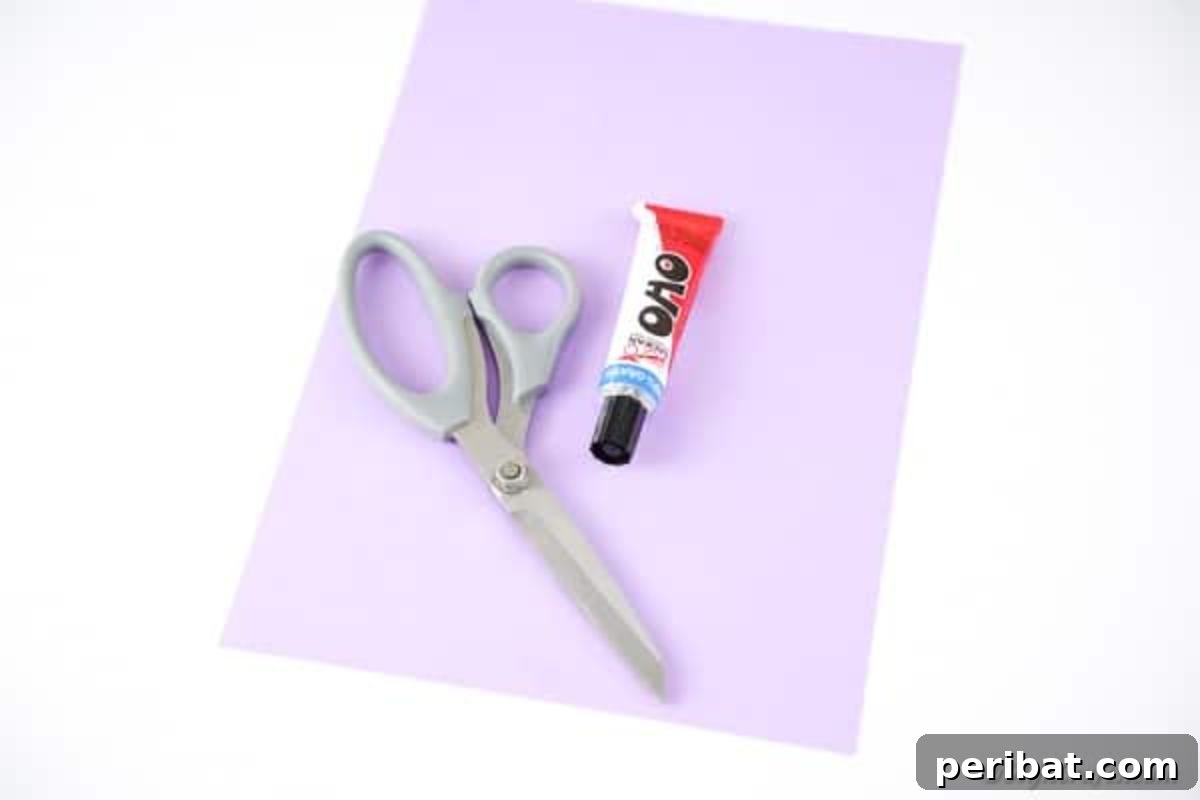 An organized flat lay displaying the essential supplies for making paper flowers: colored paper, scissors, and craft glue.