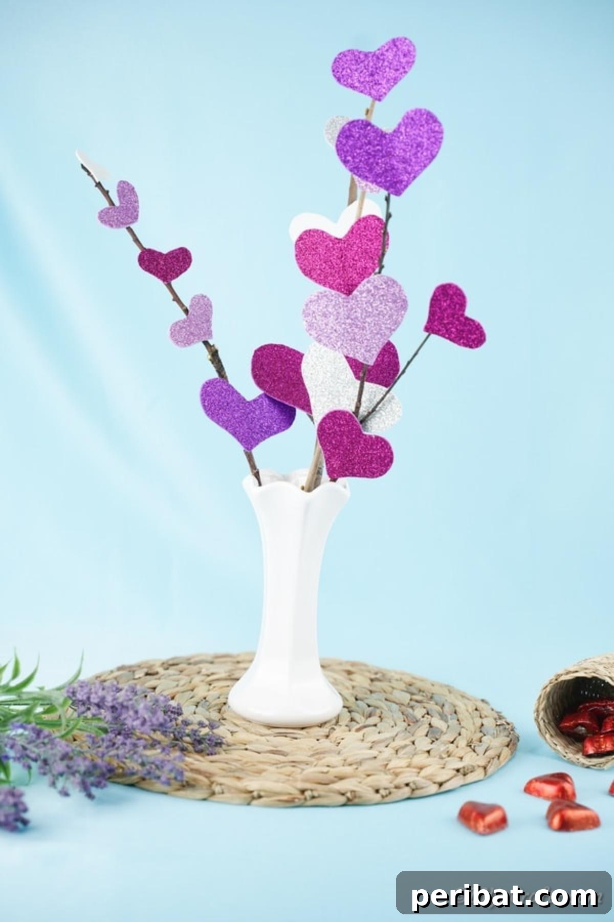 White vase of heart flowers in front of blue background
