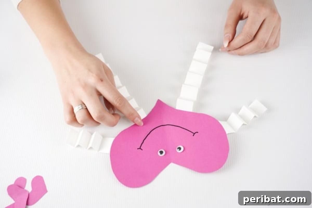 Little Hands, Loving Hearts: Kids' Valentine Paper Craft 14 Securing the accordion-folded arms and legs to the main paper heart