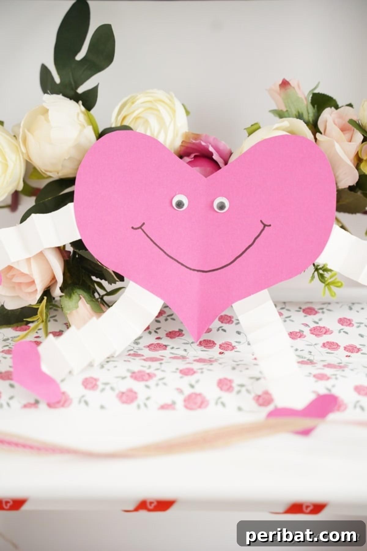 Little Hands, Loving Hearts: Kids' Valentine Paper Craft 3 Pink and white paper heart decoration in front of delicate white flowers
