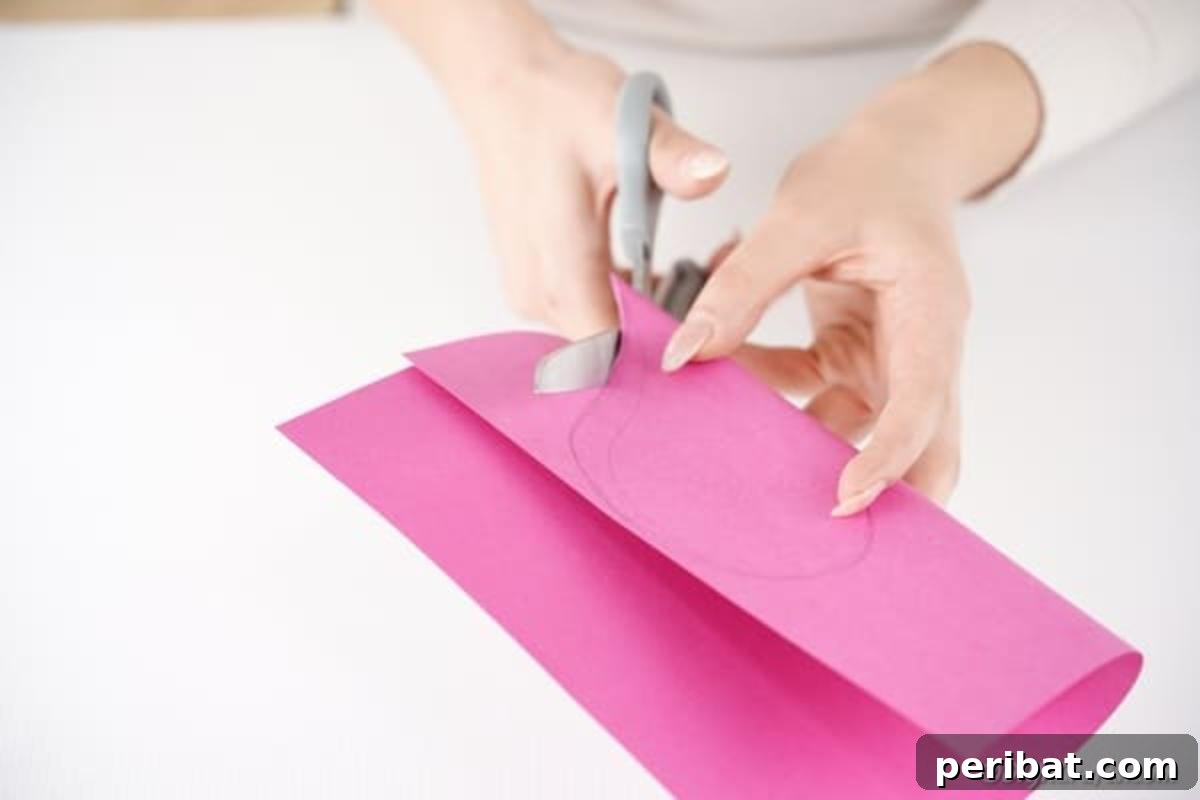 Little Hands, Loving Hearts: Kids' Valentine Paper Craft 8 Carefully cutting a large heart shape out of pink paper