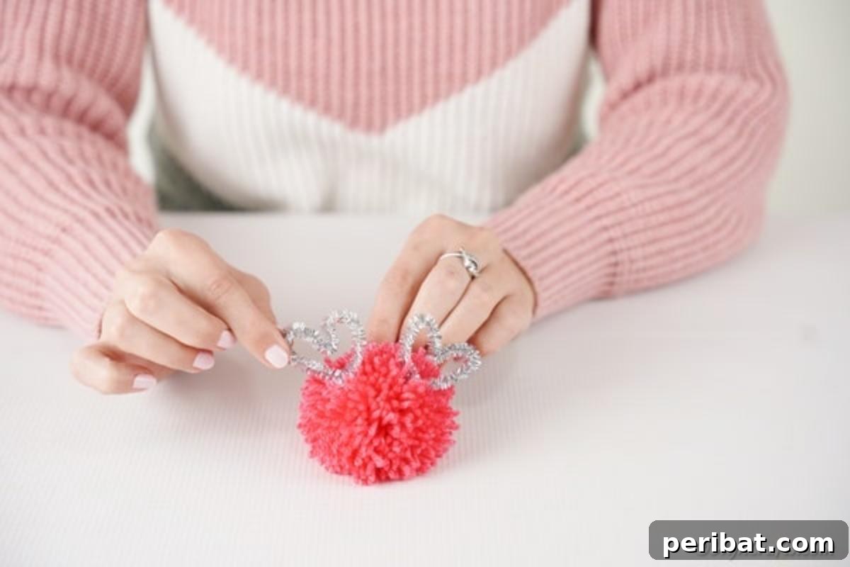 Gluing pom pom ears to monster