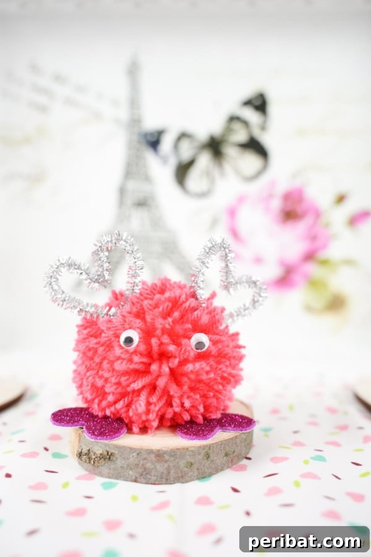 Pink monster pom pom on white surface