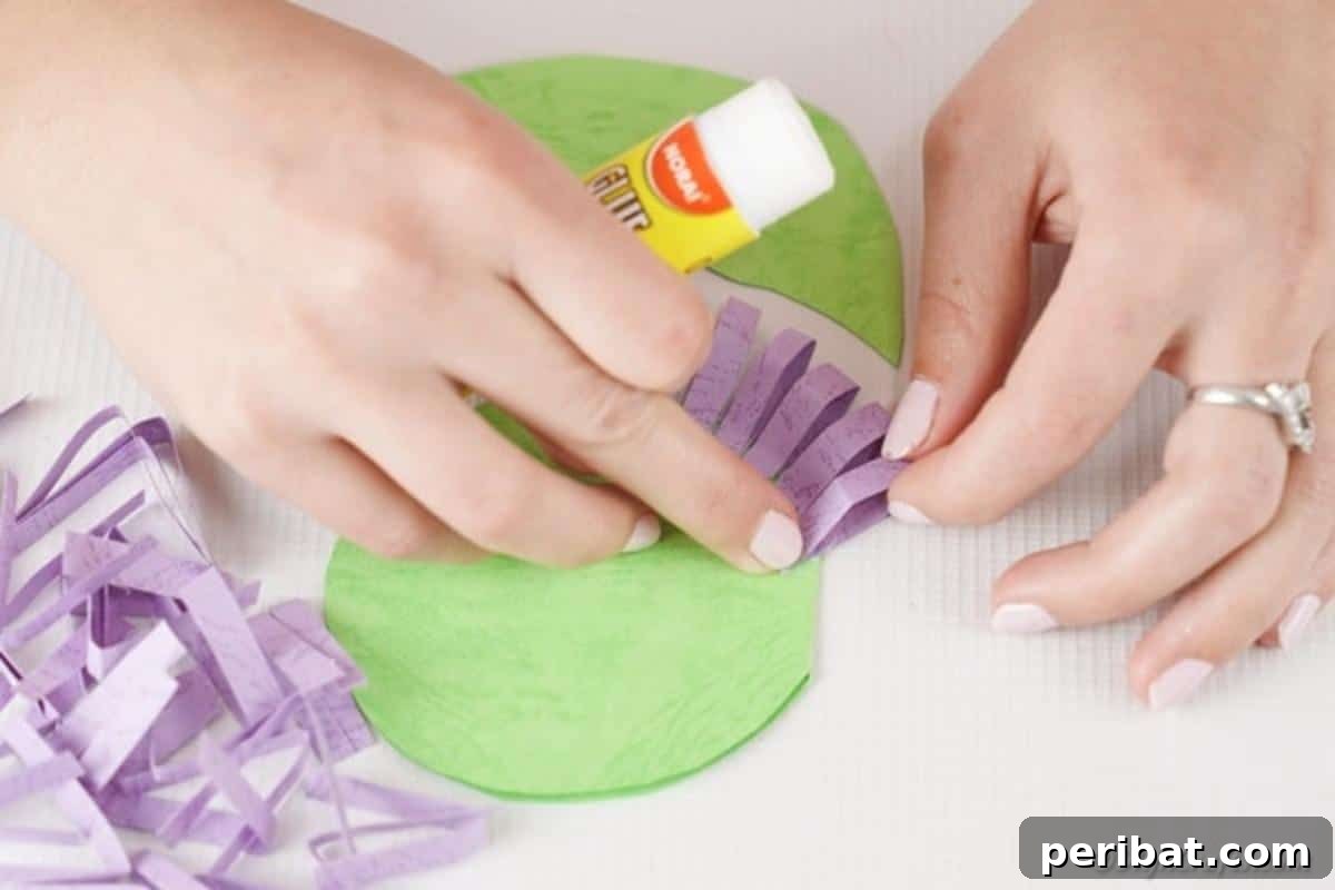 Craft Your Own Paper Flower Photo Keepsake 11 Gluing purple petal strips into place on the paper flower base
