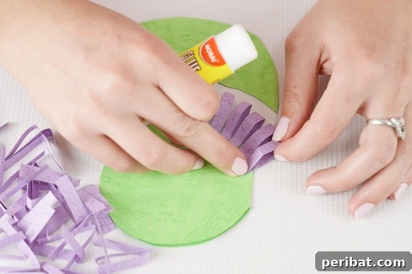 Craft Your Own Paper Flower Photo Keepsake 20 Gluing purple petals in place on paper flower