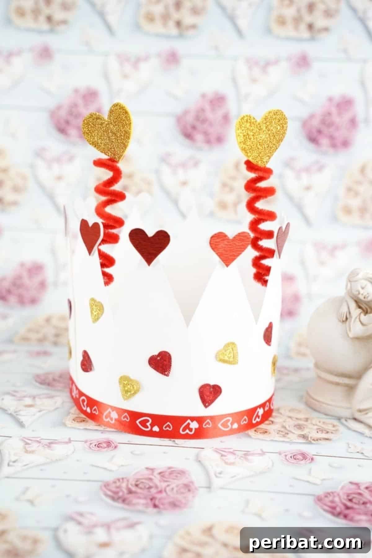 Easy Valentine Paper Crown Craft for Children 16 The completed Valentine's Day paper crown, exquisitely decorated with hearts and glitter, sits beautifully on a festive Valentine's Day themed craft paper background.