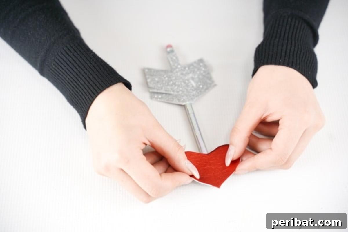 Make Your Own Valentine's Love Arrows 12 Attaching a red glitter heart to the sharpened end of the pencil to complete the Cupid's arrow look
