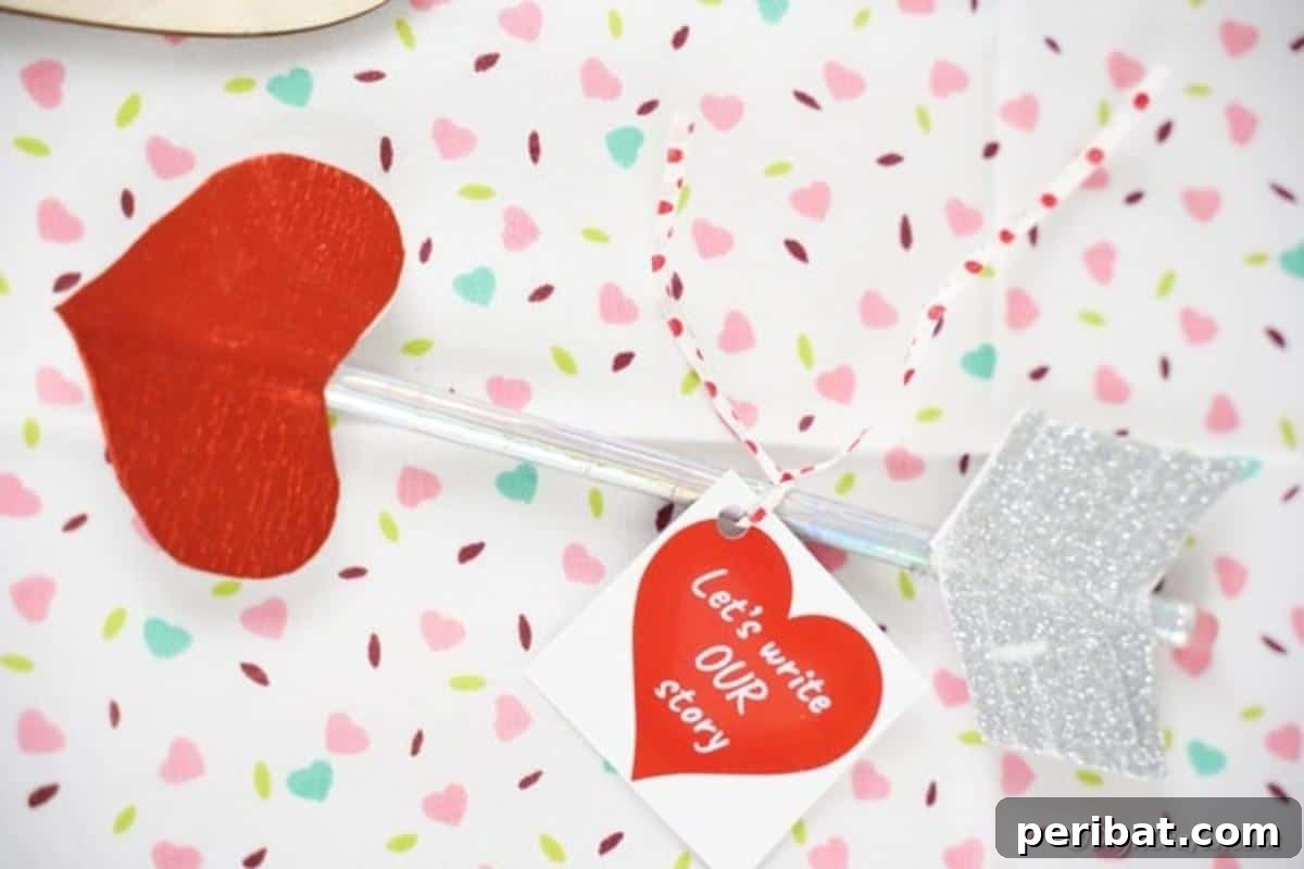 Make Your Own Valentine's Love Arrows 14 A finished Valentine Cupid's arrow pencil artfully placed on heart-patterned paper, symbolizing love and craft