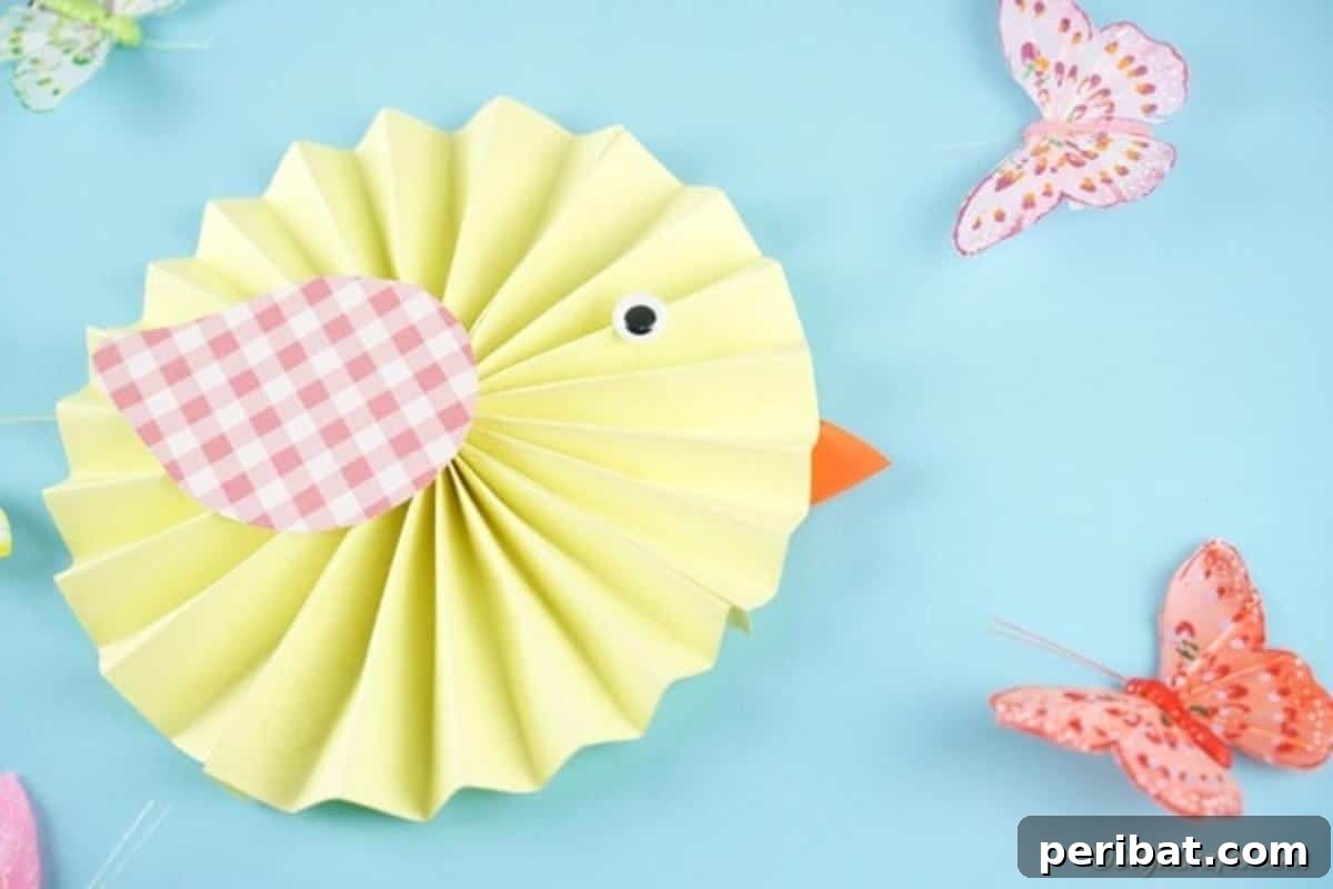 Simple & Sweet: Crafting Paper Birds with Kids 5 A vibrant yellow paper chick adorned with a googly eye and orange beak, resting on a bright blue surface next to a delicate paper butterfly, evoking a cheerful spring scene.