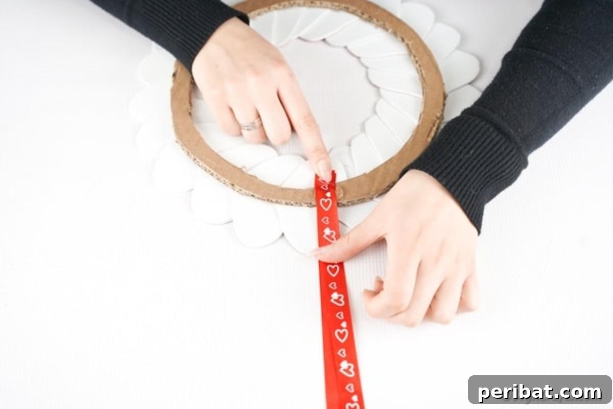 Gluing ribbon in place on heart wreath