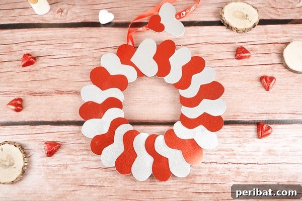 Red and silver heart wreath on wood surface