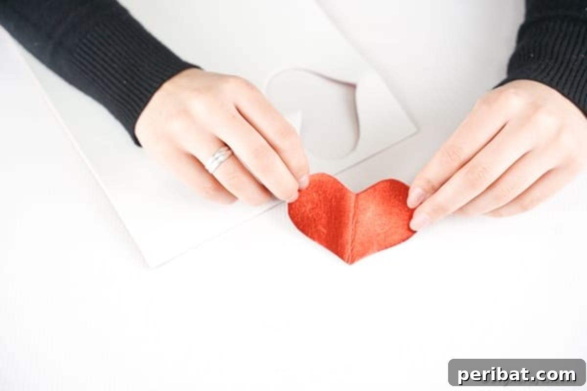 Cutting out a red heart from foam paper
