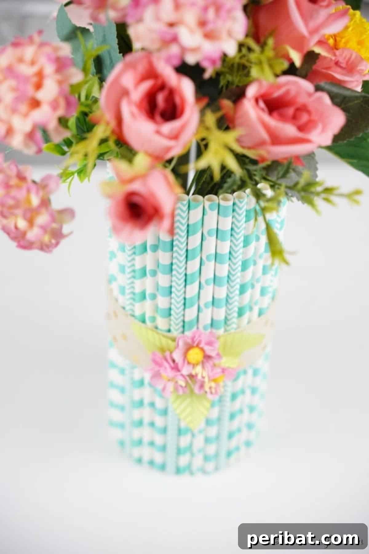 Handmade Straw-Embellished Mason Jar Vase 13 The finished mason jar vase featuring blue straws and pink flowers, ready for display