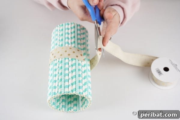 Adding a decorative ribbon to the center of a completed mason jar vase
