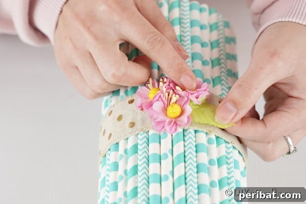 Attaching artificial flowers as embellishments to the mason jar vase