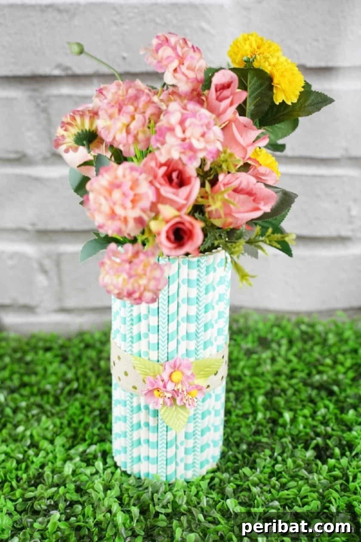 Handmade Straw-Embellished Mason Jar Vase 3 Beautiful paper straw vase filled with vibrant flowers resting on green grass