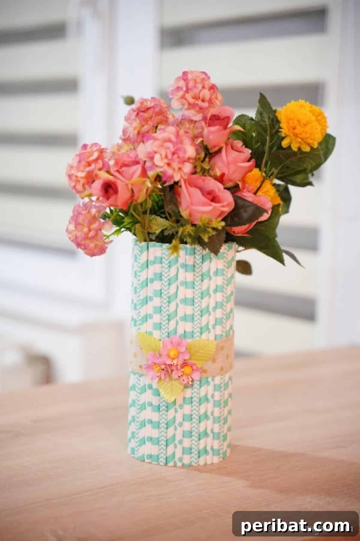 Handmade Straw-Embellished Mason Jar Vase 6 Finished mason jar vase with colorful flowers, beautifully displayed on a table