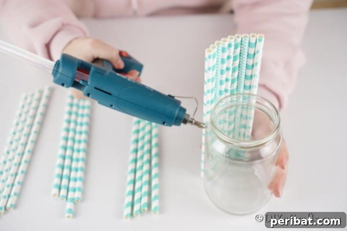 Handmade Straw-Embellished Mason Jar Vase 10 Progress of gluing multiple straws onto a mason jar vase, forming a colorful pattern