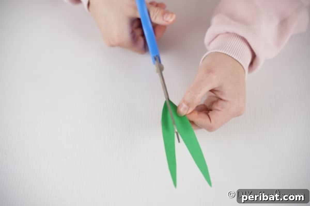 Create Charming Spring Paper Tulips 12 Cutting out green paper leaves with scissors to accompany the paper tulips