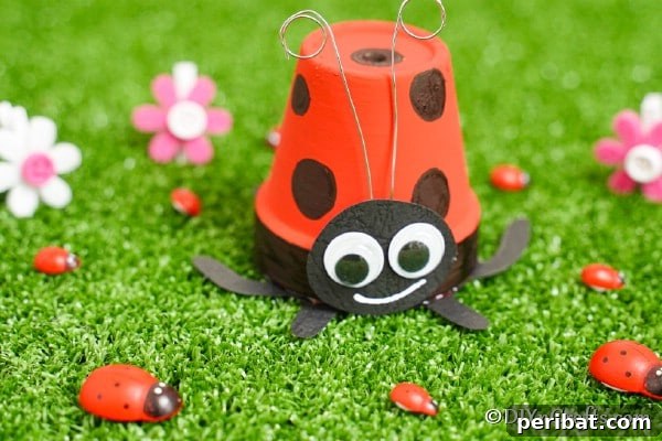 Adorable Upcycled Ladybug Planter Craft 17 A vibrant finished ladybug flower pot craft displayed amidst green grass with tiny ladybug rocks, hinting at a larger collection of garden decor.