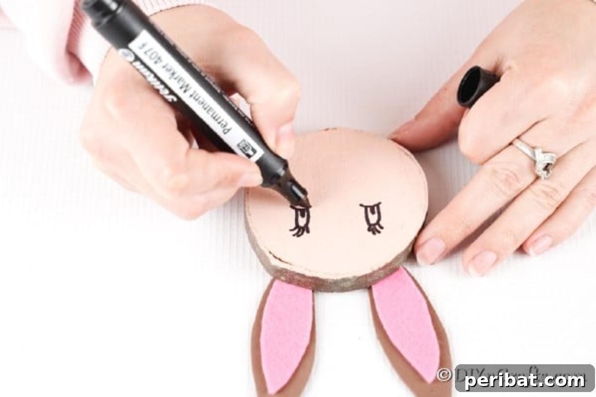 Crafting Whimsical Wood Slice Easter Bunnies 13 Drawing on eyes for the wood slice Easter bunny using a black marker.
