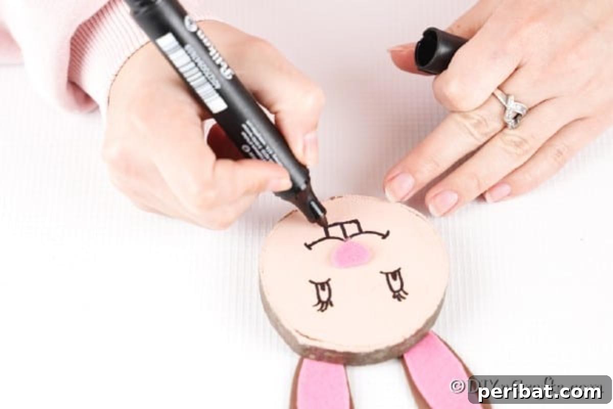 Crafting Whimsical Wood Slice Easter Bunnies 15 Drawing on the mouth and big teeth for the Easter bunny decoration.