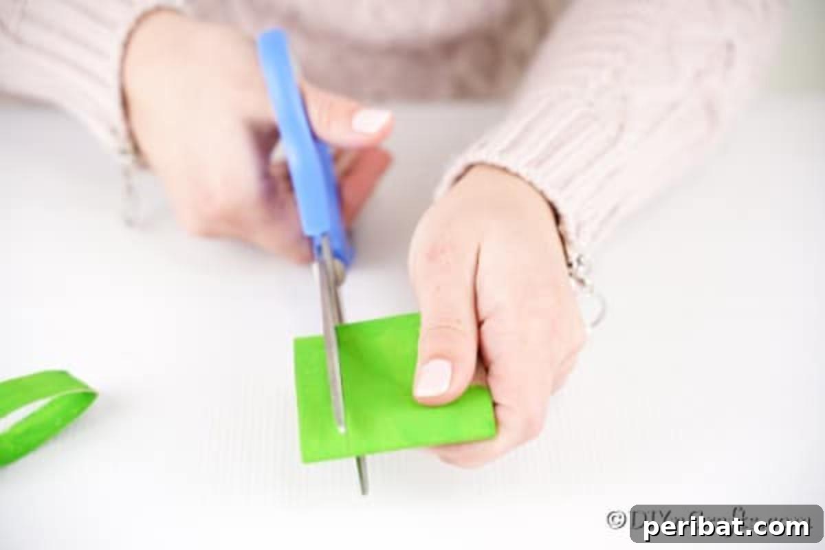 Cutting green paper roll into leaf shapes