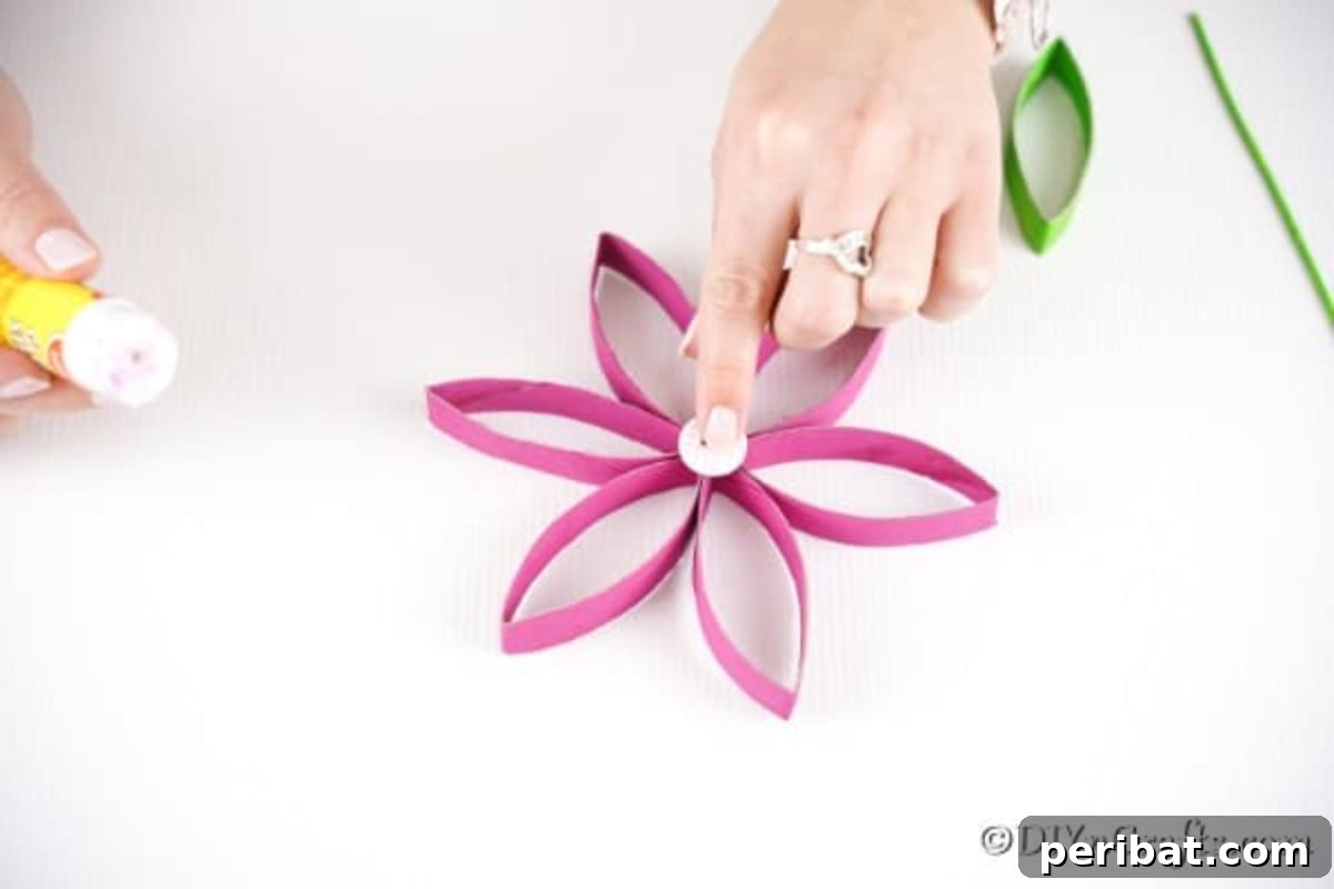 Adding button to the center of the paper roll flower