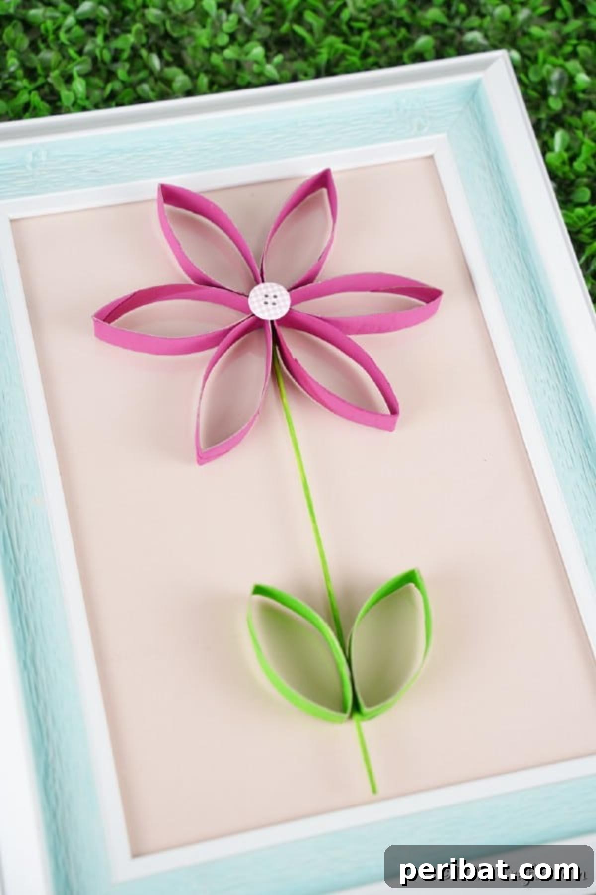 Upcycled paper roll flower attached to a picture frame