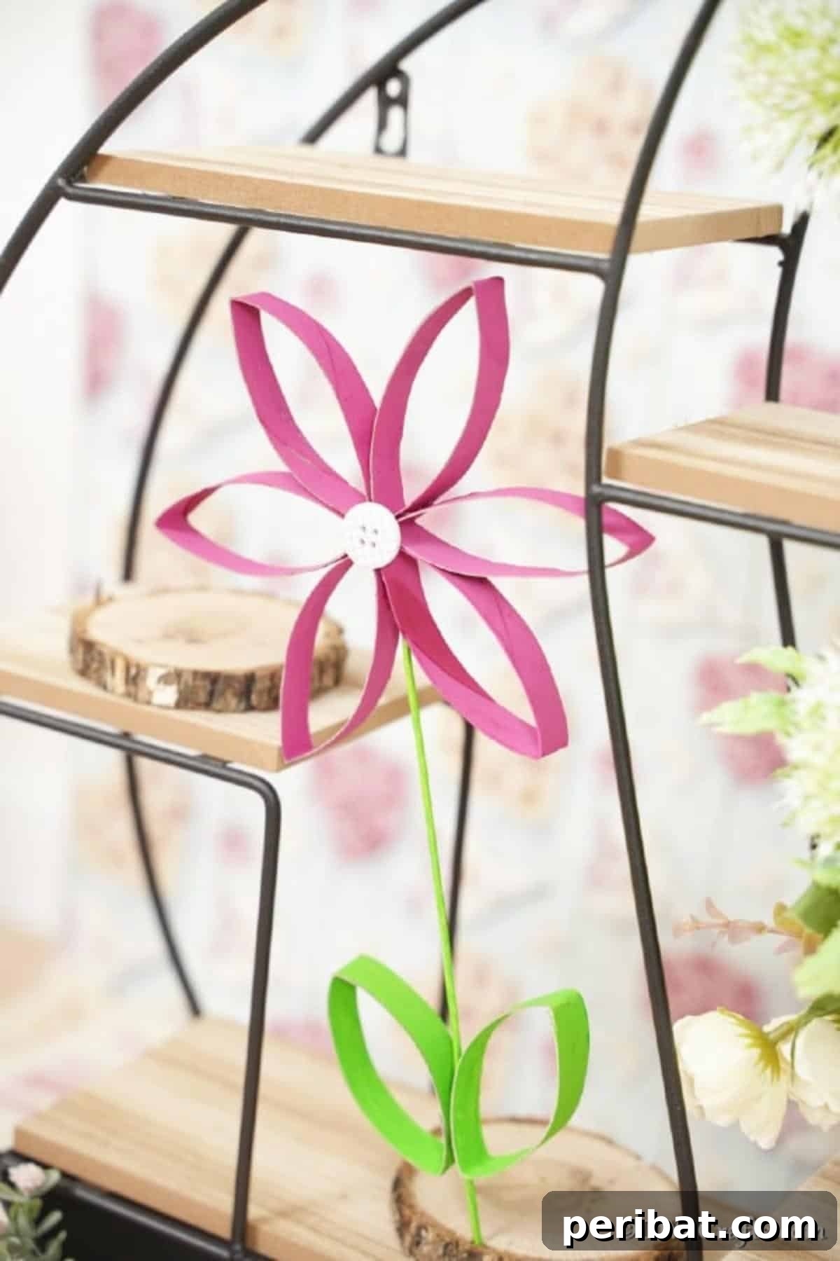 Toilet paper roll flower resting on a wooden shelf
