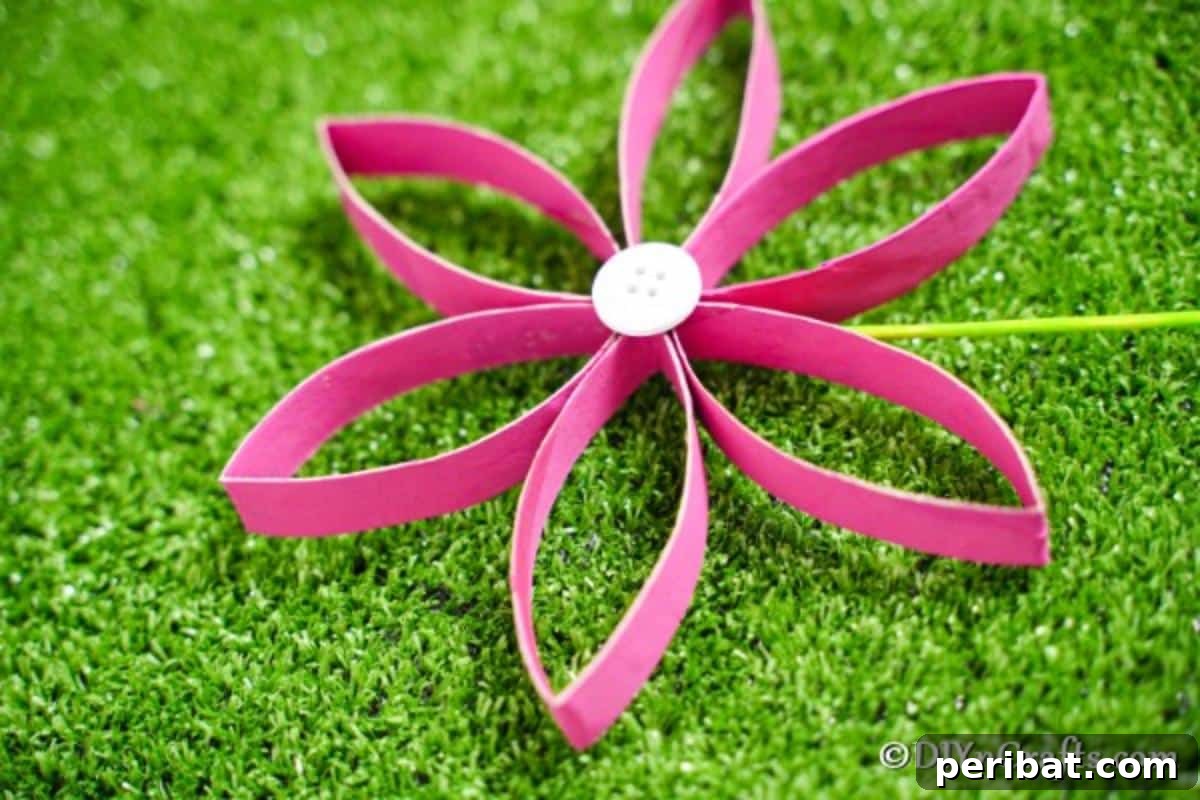 Upcycled paper roll flower placed on green grass